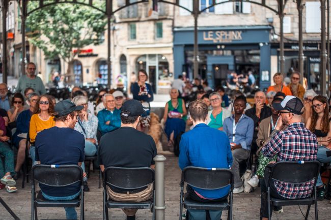 des personnes de dos parlent à un public