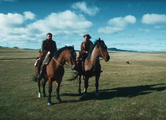 deux hommes à cheval dans une plaine
