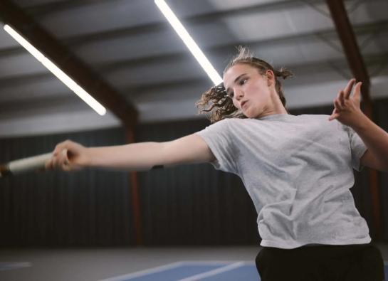 une adolescente joue au tennis