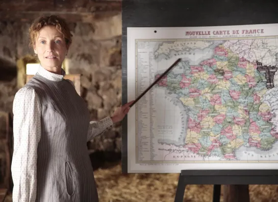 enseignante au 19e siècle devant une carte de france